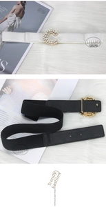 Detail of C-shaped rhinestone buckle belt and vintage gold carved buckle on plush surface