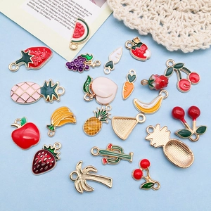 Macro detail of assorted colorful enamel fruit and plant alloy charms for DIY jewelry making