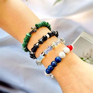 Détail de quatre bracelets en perles colorées avec perles de bambou et breloques au poignet