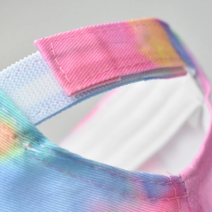 Macro detail of adjustable velcro strap on vibrant tie-dye sun visor cotton hat
