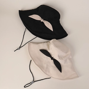 Detail of black and beige wide brim sun hats with adjustable wind ropes and bows