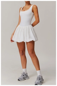 Detailed view of white pleated bubble hem on athletic dress with breathable stretch fabric