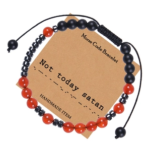 Close-up of Morse Code Bracelet with red agate and black beads on a kraft card