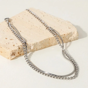 Mens double layered silver cuban and snake chain necklace on stone display base