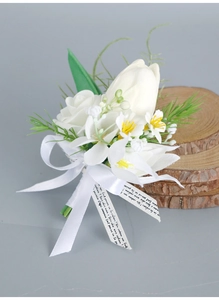 Macro detail of white artificial rose boutonniere with silk ribbon and decorative greenery