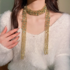 Detailed shot of a multi-strand gold beaded scarf necklace with turquoise crystals