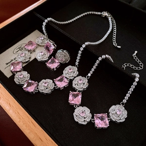 Pink zircon camellia necklace and earrings set on black velvet jewelry box background