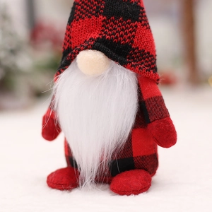 Christmas gnome doll in red and black buffalo plaid with long white beard on snowy background