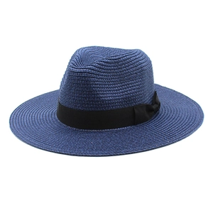 Detail of blue straw fedora hat featuring a black ribbon band and decorative bow accent