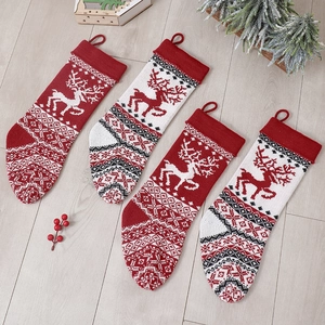 Knitted Christmas stockings with reindeer and snowflake patterns on wooden background