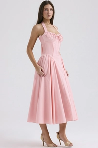 Detail of pink halter neck midi dress featuring a corsetry bodice and pleated skirt flow