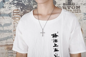 Silver cross pendant necklace on model with textured cross design and O-chain detail
