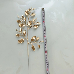 Vue détaillée de feuilles de houx artificielles dorées de 42cm avec règle de mesure