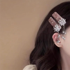 Pink fringe hair clips with pearls and sequins on a model with wavy brown hair