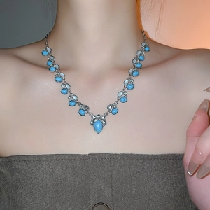 Detail of vintage turquoise teardrop pendant necklace with silver metal and crystals