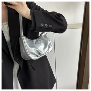 Mirror selfie showing a silver metallic crescent underarm bag styled with a black blazer