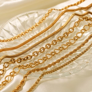 Elegant gold chain necklaces set in crystal tray with silk background for women