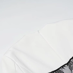 Detail of white dress back neckline featuring black floral lace and hidden zipper closure