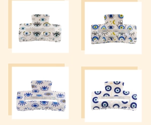 Detail of PVC hair claw clips featuring evil eye, moon and star patterns