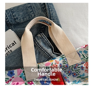 Close-up of durable reinforced cream canvas handles on a colorful floral tote bag