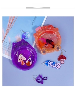 Flat lay of cat-shaped resin jewelry trays with glitter and cute handmade earrings
