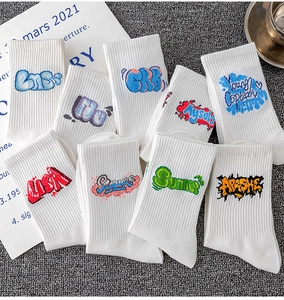 Detailed view of white cotton mid-tube sports socks with colorful graffiti letter patterns