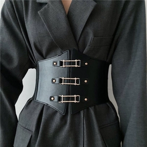 Vintage black elastic wide corset belt with triple gold buckles on a grey suit jacket