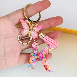 Handheld resin letter K keychain with pink butterfly and glitter heart sequins detail