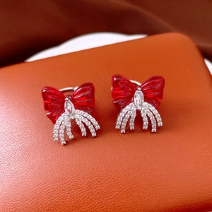 Detail of vintage red bow tassel clip-on earrings with shimmering zircon fringe accents