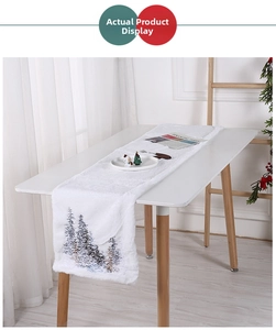 Close-up of a white plush Christmas table runner with fine pine tree embroidery detail
