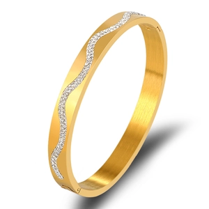 Macro shot of gold stainless steel bangle with wavy rows of sparkling white zircons