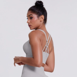 Dettaglio del reggiseno sportivo grigio chiaro con spalline incrociate e leggings yoga