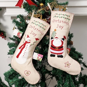 Embroidered Christmas stockings set with Santa and Snowman hanging on a festive holiday tree
