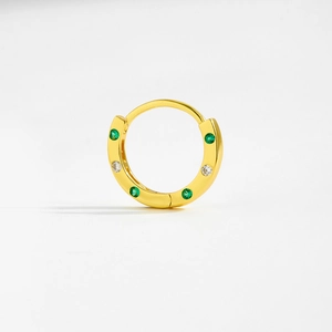 Close-up of gold hoop earrings featuring alternating green and clear cubic zirconia stones