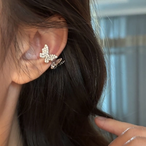 Detail shot of a silver butterfly ear cuff with cubic zirconia on a female ear
