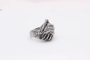 Close-up of vintage oxidized titanium steel ring featuring detailed skeleton hands design