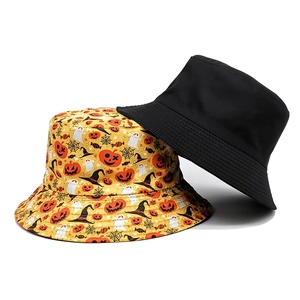 Flat lay of reversible bucket hats featuring black side and yellow Halloween pumpkin patterns