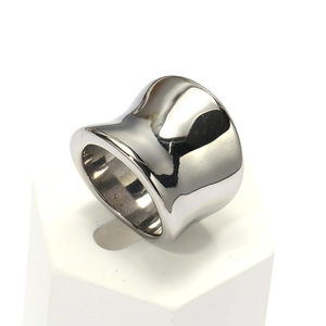 Close-up of polished stainless steel wide ring with organic curved design on white base