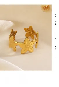 Macro di anello a fiore placcato oro 18K con texture opaca su seta bianca morbida