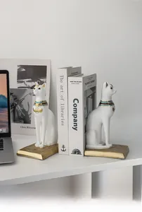 Detailed view of Egyptian Bastet cat bookends with ornate gold collars on a desk