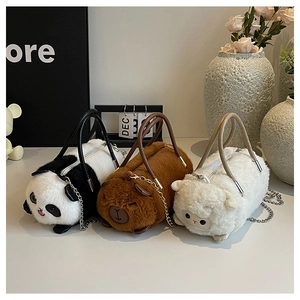 Dettaglio delle texture morbide animali e catene metalliche sulle borse a cilindro peluche