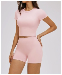 Detail of light pink ribbed crop top and high waist shorts set for yoga and fitness