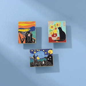 Detailed close-up of three enamel pins featuring creative black cat art designs