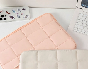 Quilted laptop sleeve in pink and white waterproof fabric with anti-shock padding detail