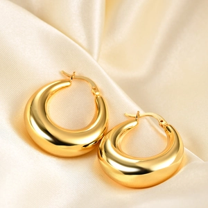 Polished 18K gold chunky geometric hoop earrings displayed on champagne silk fabric