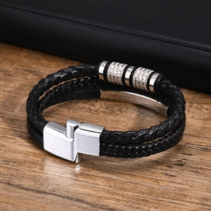 Détail d'un bracelet multicouche en cuir tressé noir avec anneaux métalliques argentés