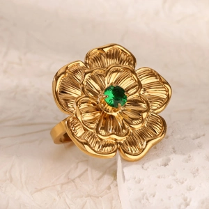 Vista macro dettagliata di un anello a fiore dorato con pietra preziosa verde smeraldo