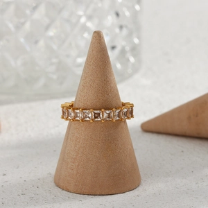 Close-up of 18K gold plated ring with square-cut cubic zirconia on a wooden stand
