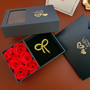 Elegant black gift box featuring red soap roses and a golden bow brooch with a matching bag