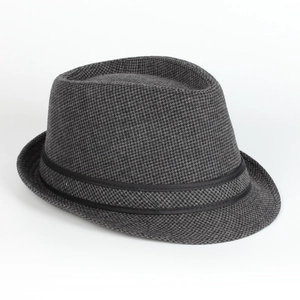 Macro detail of houndstooth wool fabric texture and black ribbon on a vintage fedora